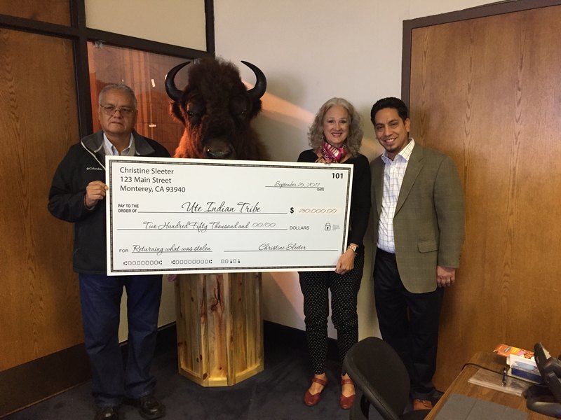 (Photo courtesy of Ute Land Trust) From left, Ronald Wopsock, a member of the Ute Indian Tribe Business Committee, accepts a $250,000 check from Christine Sleeter (middle). Director of Ute Land Trust Robert Lucero stands to the right.